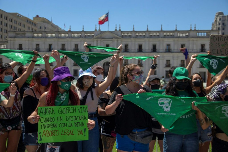 Feminist activists hold up green handkerchiefs -- in favor of the decriminalization of abortion -- during a demonstration outside La Moneda presidential palace in Santiago on January 13, 2021