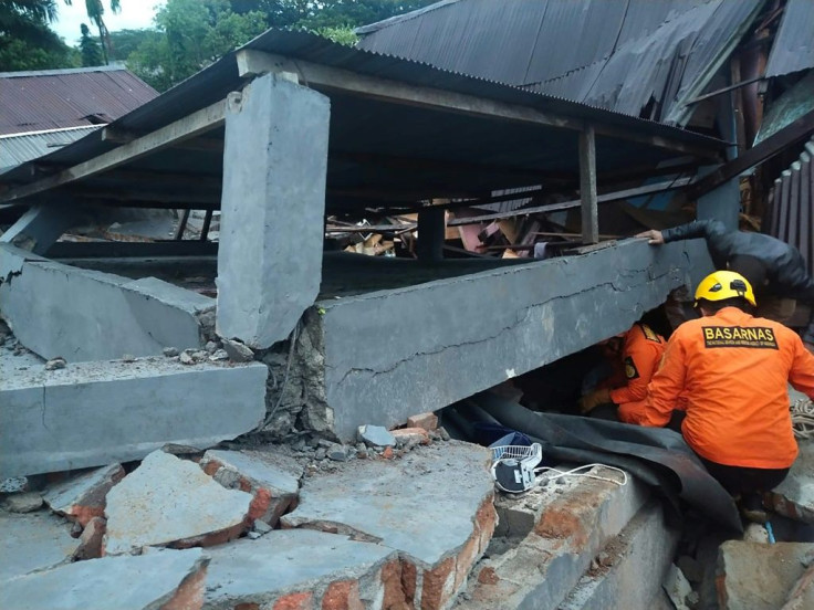 Rescuers look for survivors trapped in a collapsed building in Mamuju, the capital of Sulawesi, after the overnight quake