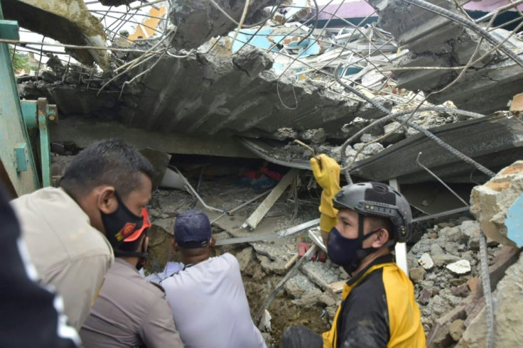 Rescuers search for survivors at the Mitra Manakarra hospital in Mamuju city, where as many as 20 patients and staff are trapped beneath the rubble after the hospital was flattened when a 6.2-magnitude earthquake rocked Indonesia's Sulawesi island.