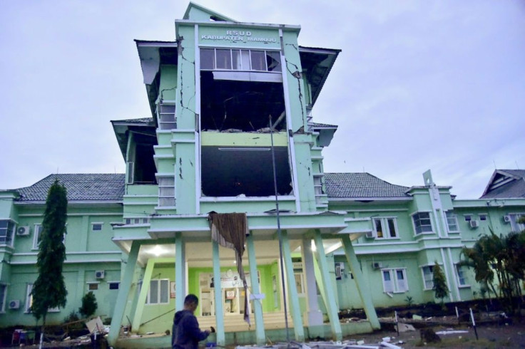 A man walks by a damaged hospital in Mamuju city after a 6.2-magnitude earthquake rocked Indonesia's Sulawesi island