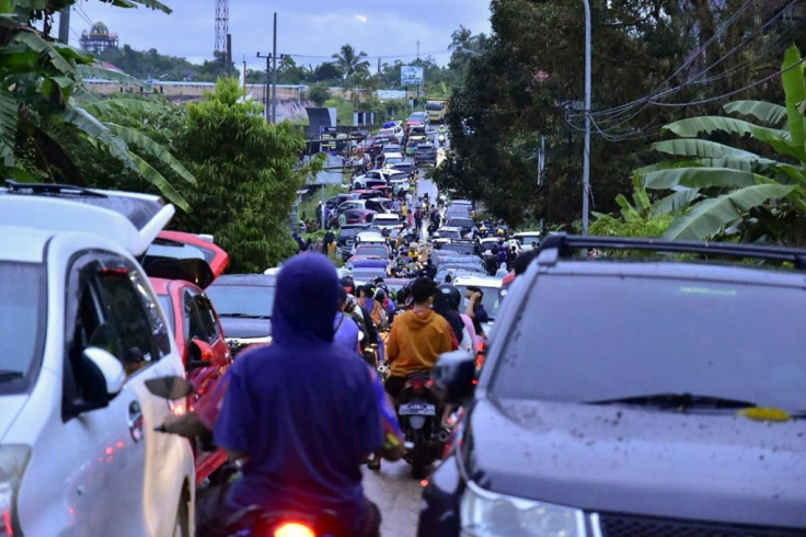 Residents crowd a road as they attempt to leave Mamuju after a 6.2-magnitude earthquake rocked Indonesia's Sulawesi island