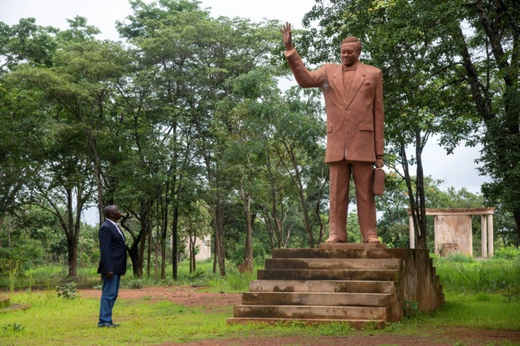 Historian Guillaume Nkongolo stands by Lumumba's statue, at a neglected memorial in Katanga
