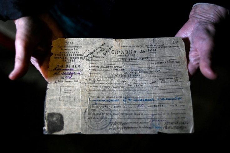 Yelizaveta Mikhaylova displays a document belonging to her father Semyon