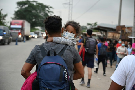 The Honduran migrants set off along side roads with backpacks, some with the Honduras flag, many with small children in their arms, and most with facemasksÂ to protect against the coronavirus