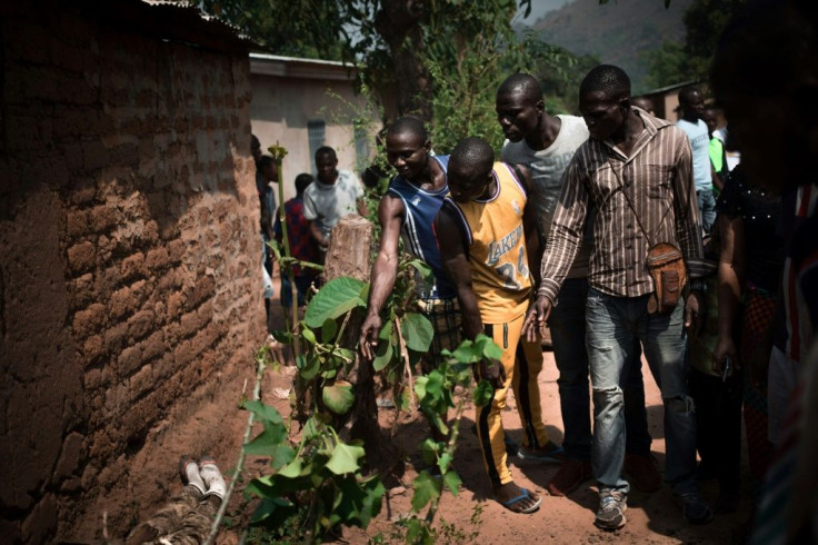 Men gathered round the body of a rebel of the Coalition of Patriots for Change (CPC) killed by loyalist forces in Bangui on January 13, 2021. Rebel forces in the Central African Republic launched two attacks on January 13, 2021 close to the capital Bangui