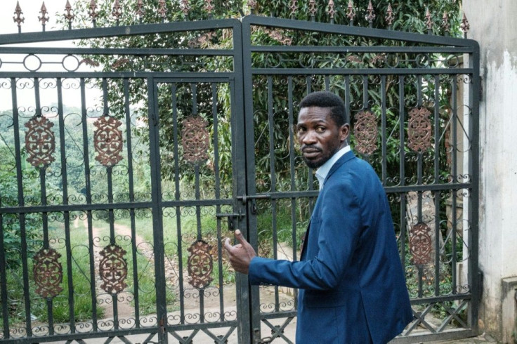 Ugandan opposition leader Bobi Wine at the gate of his home, which soldiers have surrounded after he alleged mass electoral fraud