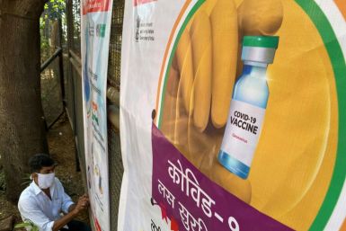 A worker sets up a poster at a coronavirus vaccination centre in Mumbai on January 15, 2021, with the Indian government aiming to inoculate around 300 million people by July