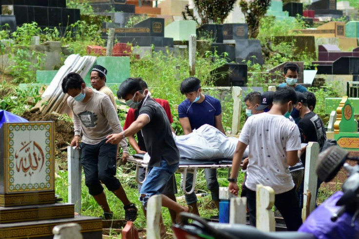 Search-and-rescue workers pulled dozens of bodies from beneath crumpled buildings in Mamuju