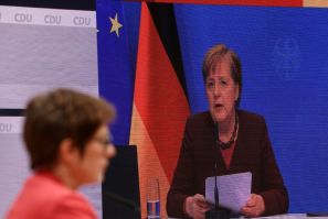 A screen shows German Chancellor Angela Merkel (R) delivering a speech as outgoing leader of the Christian Democratic Union (CDU).