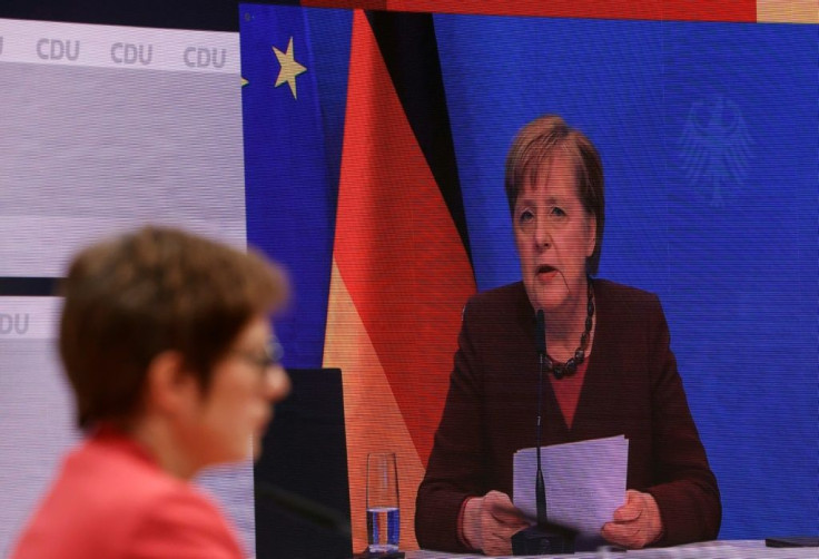 A screen shows German Chancellor Angela Merkel (R) delivering a speech as outgoing leader of the Christian Democratic Union (CDU).