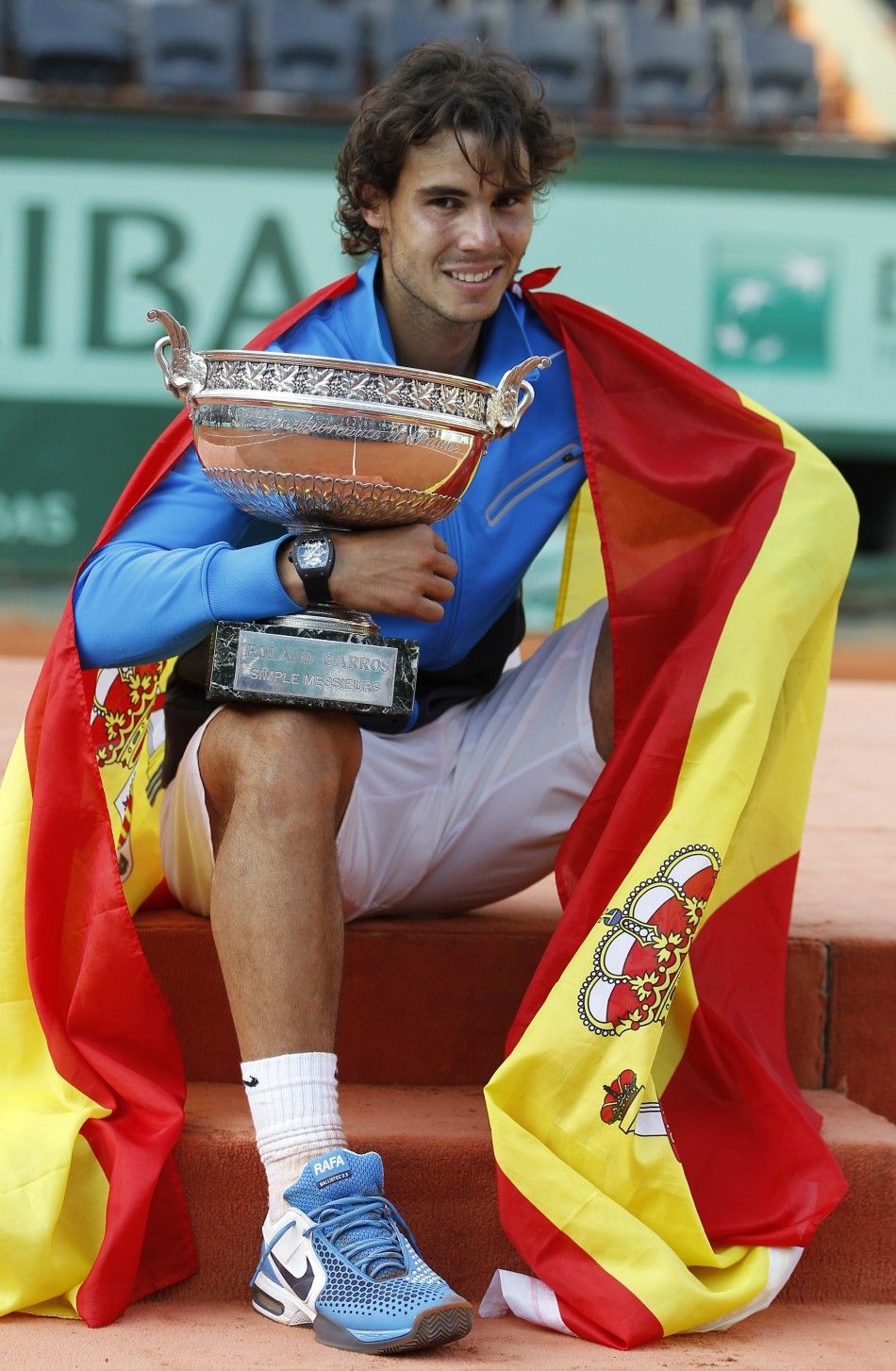 Nadal of Spain poses with the trophy and the Spanish flag during the ceremony