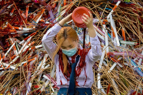 The "Bad Student" group piled rulers, scissors and canes up against the building; then one of their members poured crimson paint over it and herself