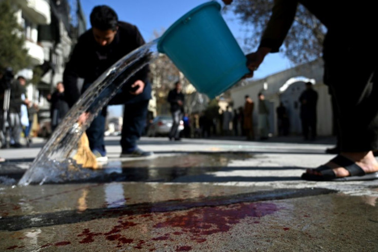 Residents wash the road after the Kabul ambush