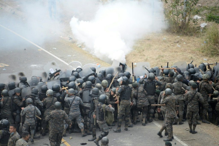 Guatemalan security forces fire tear gas at Honduran migrants taking part of a caravan heading to the United States