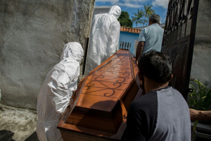 Workers remove the body of a Covid-19 victim in Brazil, which has seen a spike in infections