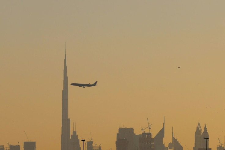 A commercial airplane flies past Burj Khalifa as it starts landing at Dubai international airport in the United Arab Emirates