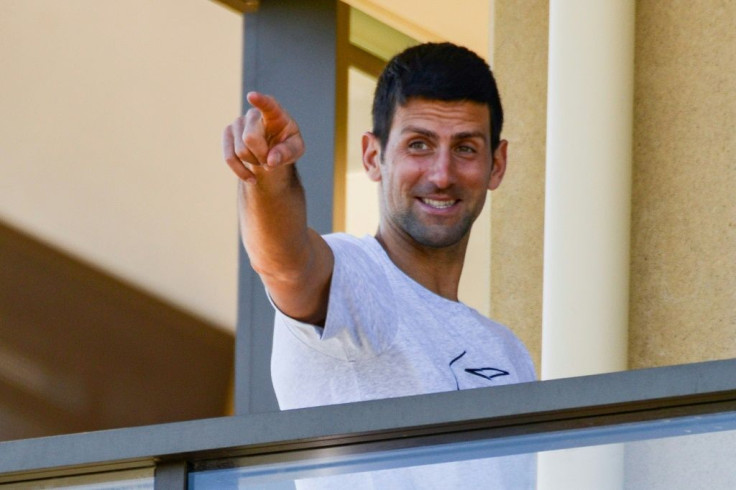 Men's world number one tennis player Novak Djokovic gestures from his hotel balcony in Adelaide, one of the locations where players have quarantined for two weeks ahead of the Australian Open tennis tournament in Melbourne