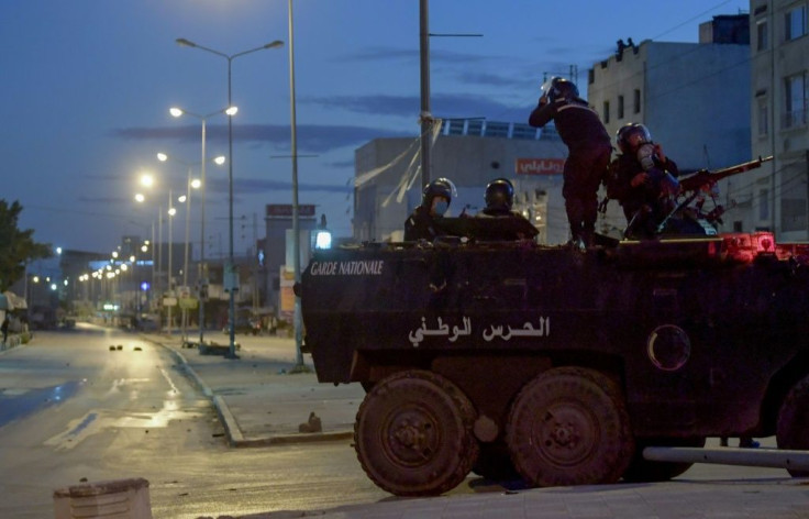 Tunisian National Guard troops on an armoured vehicle, stationed on a street amid clashes with demonstrators in the Ettadhamen neighbourhood in the capital Tunis on Sunday