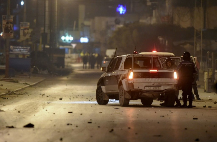 Tunisian police block a road in the working-class district of  Ettadhamen on the edge of Tunis amid clashes with protesters on January 17, 2021