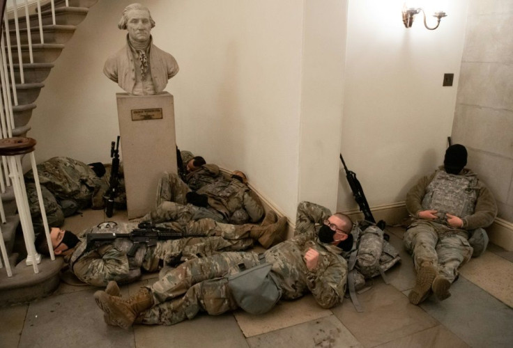 Members of the National Guard rest in the Rotunda of the US Capitol after security was beefed up following the attack on the building by supporters of President Donald Trump