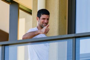 Under-fire: Novak Djokovic gestures from his hotel balcony in Adelaide, one of the locations where players are quarantined for two weeks ahead of the Australian Open in Melbourne