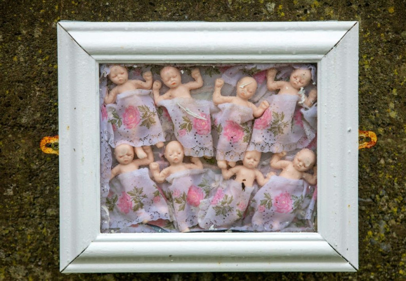 Framed baby dolls at a shrine in Tuam, County Galway erected in memory of up to 800 children who were allegedly buried at the site of the former home for unmarried mothers run by nuns