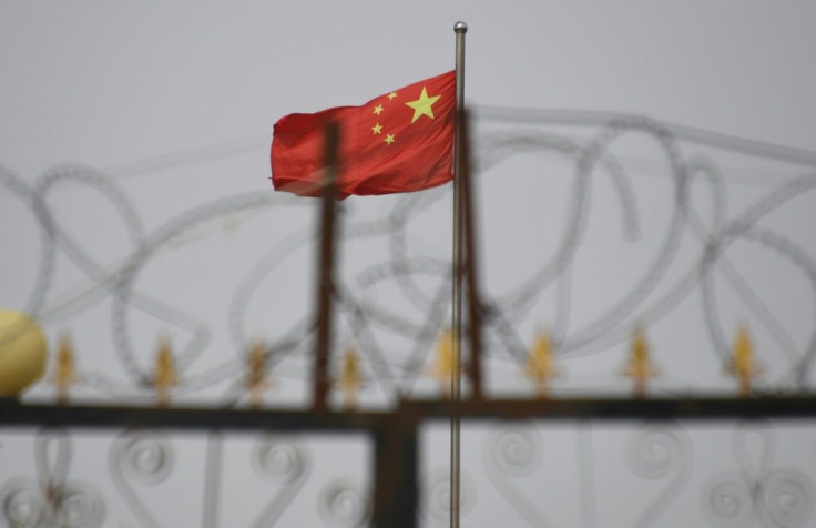 The Chinese flag behind razor wire at a housing compound in Yangisar in China's western Xinjiang region in June 2019