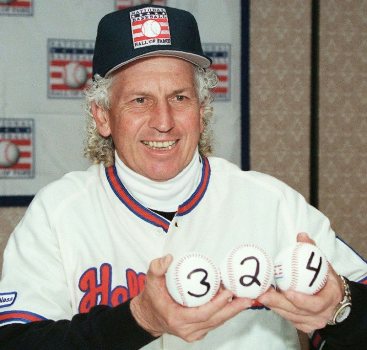 Pitcher Don Sutton, at a press conference for his induction into the National Baseball Hall of Fame in 1998, holds up three baseballs showing the number of games (324) he won in his 23-year major league baseball career