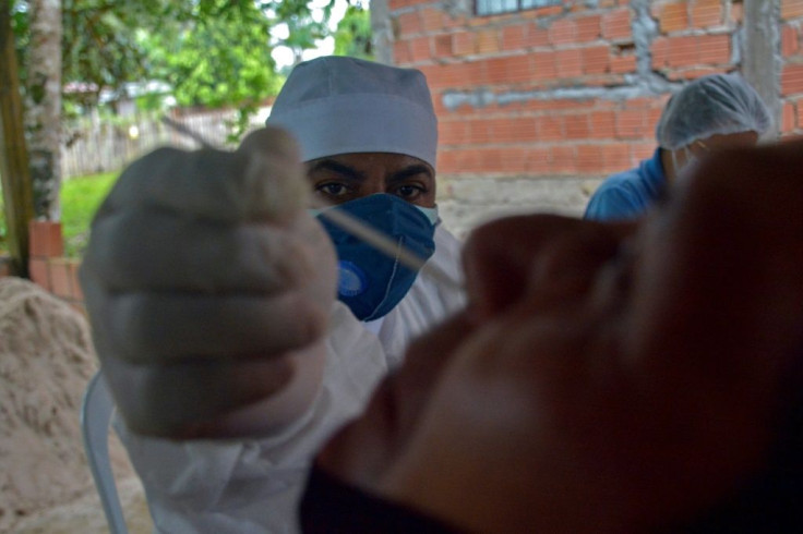 A health worker collects a swab sample from a resident to perform a COVID-19 test 