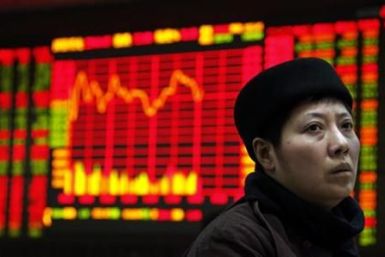 An investor sits at a terminal in front of a screen displaying stock information at a brokerage house in the financial district of Beijing