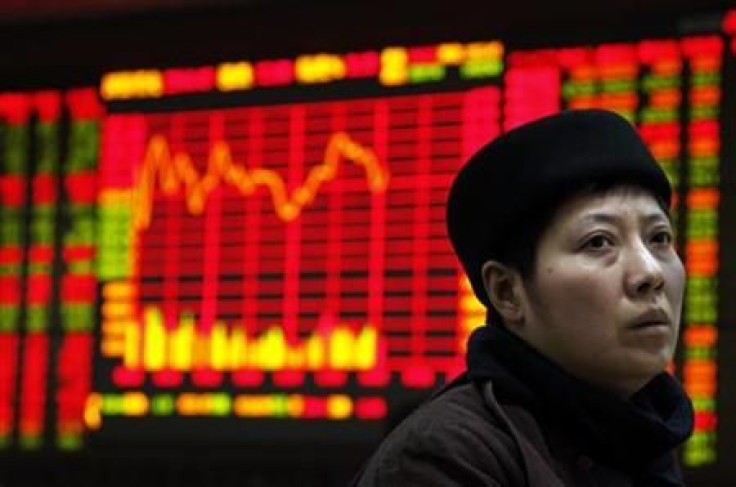 An investor sits at a terminal in front of a screen displaying stock information at a brokerage house in the financial district of Beijing