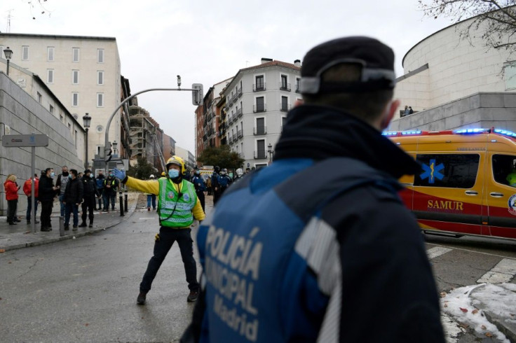 Emergency personnel secure the area surrounding a building damaged in an explosion in Madrid