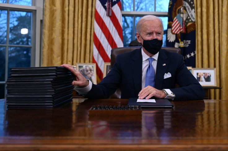 US President Joe Biden prepares to sign a series of orders in the Oval Office of the White House on his first day in office