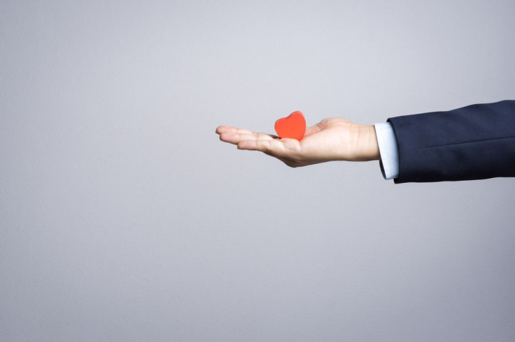 Business man hand with wooden red heart object