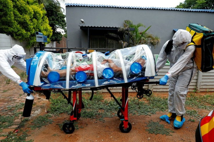 Paramedics take a man showing symptoms of COVID-19 to hospital near Pretoria in South Africa. A new strain of the virus that emerged in the country is already spreading around the world