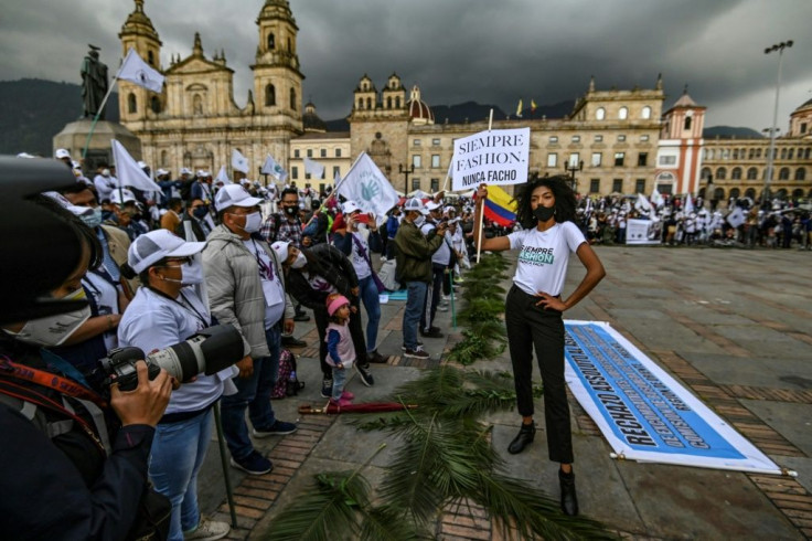 A model presents a creation by former FARC combatants during a demonstration demanding peace accords be respected, at Bolivar square in Bogota in November 2020