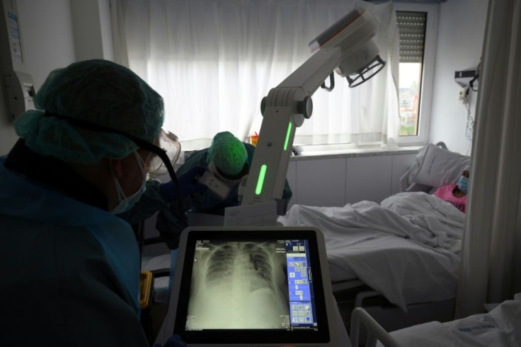 A healthcare worker checks a patient's X-ray at the Covid-19 wing of the Hospital Del Mar in Barcelona. Four of the hospital's 12 floors are devoted to coronavirus patients