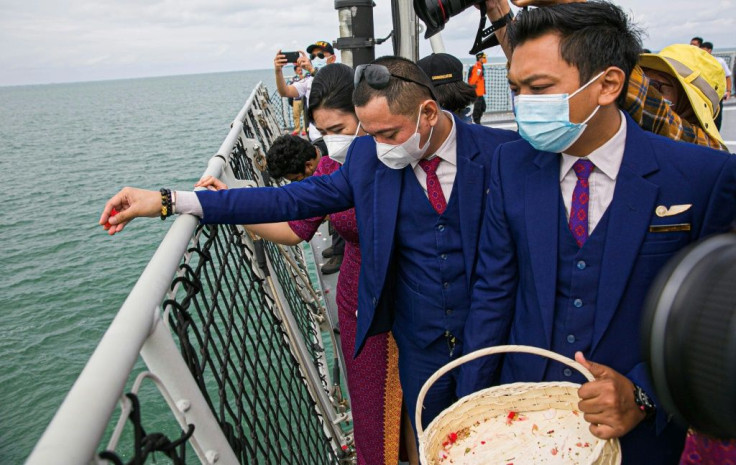 Dozens of relatives and Sriwijaya Air crew members tossed red petals from the deck of a navy ship, some overcome with emotion