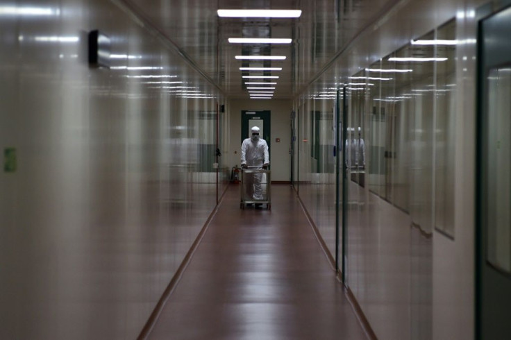 An employee in protective gear pushes a trolley inside a lab at India's Serum Institute in Pune, where coronavirus vaccines are being manufactured