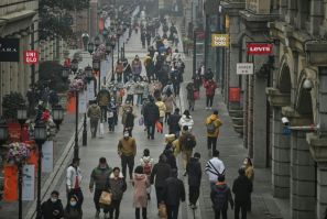People walk along a street in Wuhan on Saturday, one year after the city went into lockdown to curb the spread of Covid-19