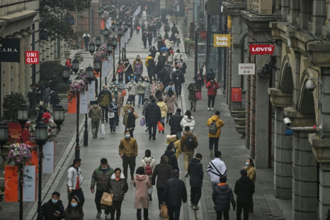 People walk along a street in Wuhan on Saturday, one year after the city went into lockdown to curb the spread of Covid-19