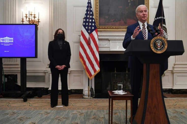 US President Joe Biden speaks about his Covid-19 response before signing executive orders, as Vice President Kamala Harris looks at the White House on January 22, 2021