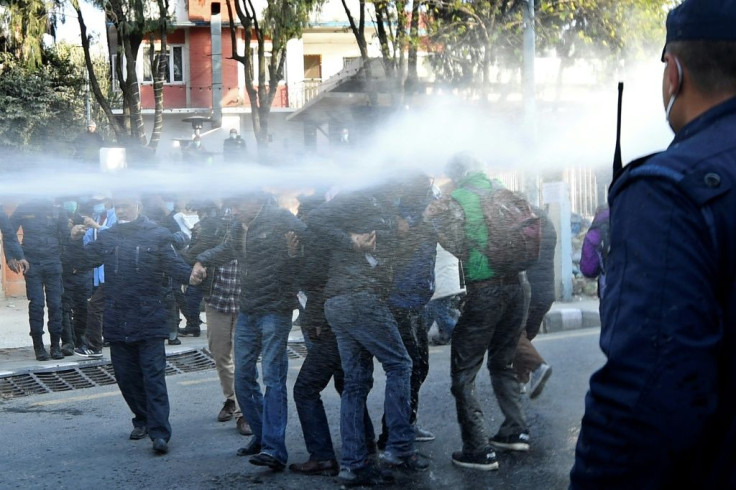 Police use water cannon to disperse protesters  during a demonstration against the dissolution of the country's parliament in Kathmandu