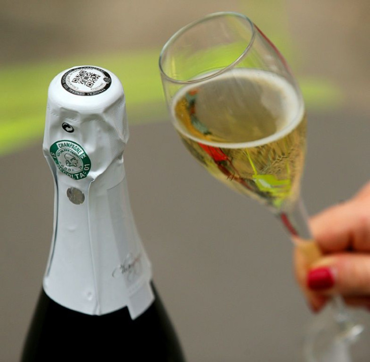 (FILES) A file photo taken on May 6, 2019 shows a glass of champagne next to a bottle which label contains a QR code to guarantee its traceability in Epernay, eastern France, at the General Syndicate of Winegrowers of Champagne (SGV).Champagne sales fell 