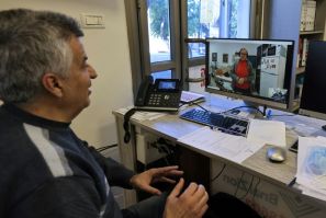 Holocaust survivor Naomie Lichthaus, 86, appears on the screen in a video call with Shimon Shabag of Israel's Yad Ezer La-Haver foundation