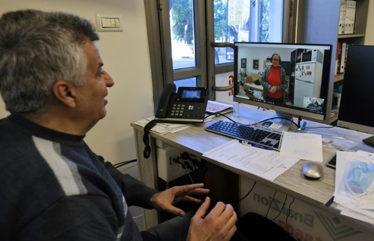 Holocaust survivor Naomie Lichthaus, 86, appears on the screen in a video call with Shimon Shabag of Israel's Yad Ezer La-Haver foundation