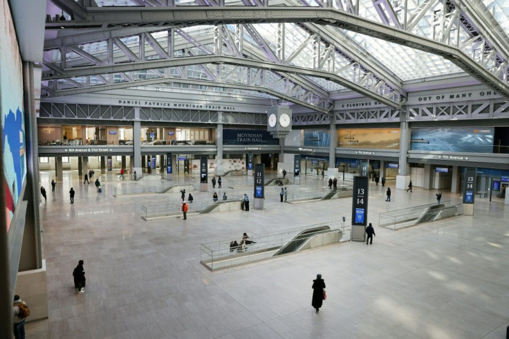 A handful of people walk through the largely deserted $1.6 billion new Moynihan Train Hall in Manhattan