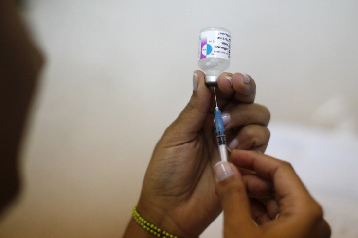 A nurse prepares a vaccine against the influenza 