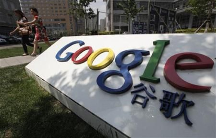 Women walk past the logo of Google in front of its former headquarters in Beijing