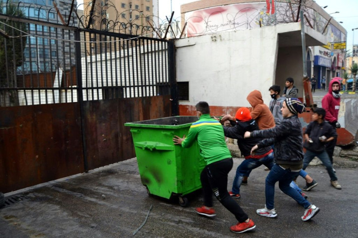 Lebanese protesters ram the gate outside the Serail, headquarters of the governorate of North Lebanon, in the port city of Tripoli on January 27, 2021